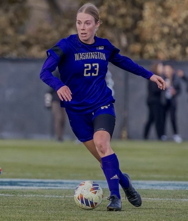 Husky Fellow Lucy Newlin dribbling soccer ball 